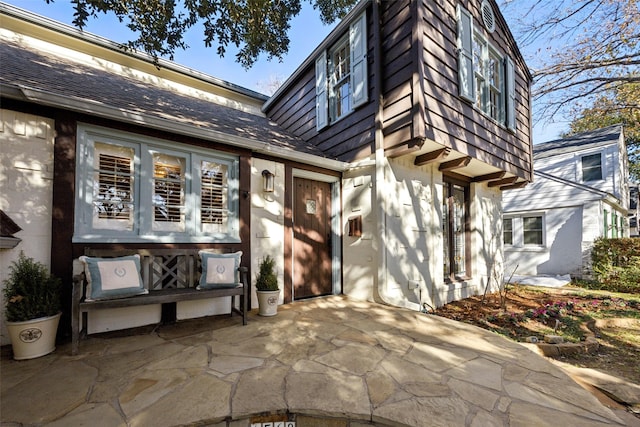 view of exterior entry with a patio area