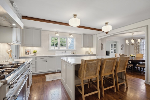 kitchen with backsplash, dark hardwood / wood-style flooring, a kitchen bar, a center island, and custom range hood