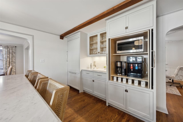 kitchen with dark hardwood / wood-style flooring, beam ceiling, tasteful backsplash, and white cabinets