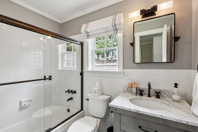 full bathroom with bath / shower combo with glass door, vanity, crown molding, and toilet