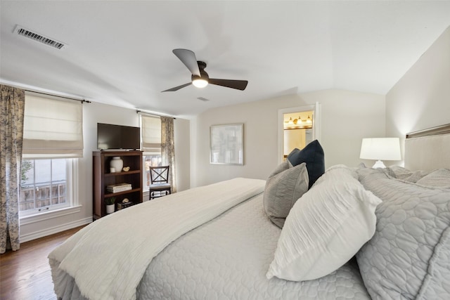 bedroom with connected bathroom, hardwood / wood-style floors, vaulted ceiling, and ceiling fan