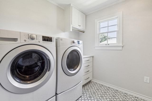 washroom with cabinets, ornamental molding, and washing machine and clothes dryer