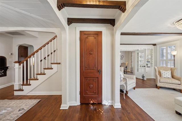 foyer entrance with dark wood-type flooring and beamed ceiling