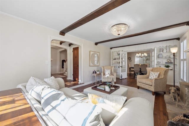 living room featuring beamed ceiling, dark hardwood / wood-style flooring, and an inviting chandelier