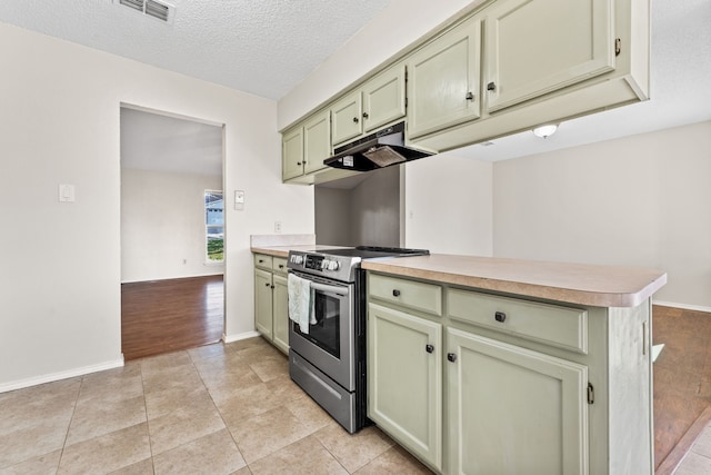 kitchen featuring light tile patterned flooring, a textured ceiling, green cabinetry, stainless steel range with electric cooktop, and kitchen peninsula