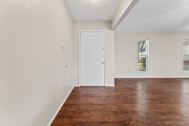 entryway with dark wood-type flooring and a textured ceiling