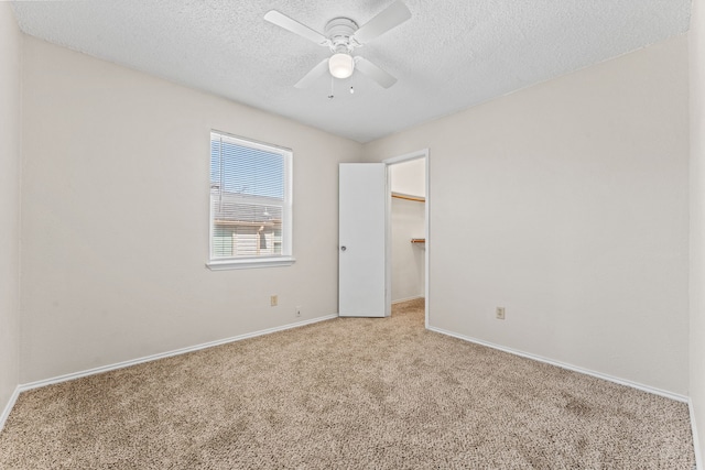 unfurnished room featuring light colored carpet, a textured ceiling, and ceiling fan