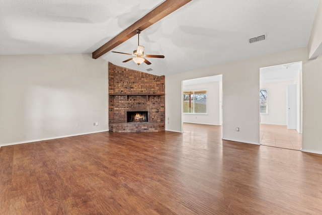 unfurnished living room with lofted ceiling with beams, ceiling fan, hardwood / wood-style flooring, and a fireplace