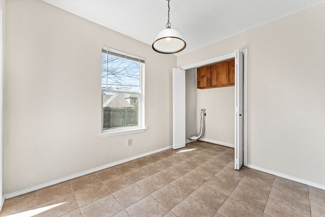 empty room featuring light tile patterned flooring and a textured ceiling