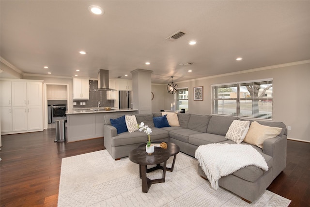 living room featuring hardwood / wood-style flooring, crown molding, and washer / dryer