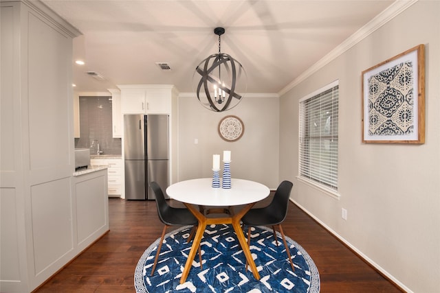 dining space featuring ornamental molding, dark hardwood / wood-style flooring, sink, and a notable chandelier