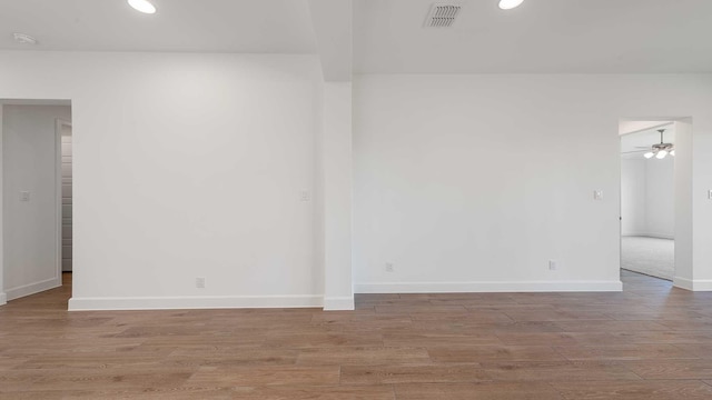 unfurnished room featuring a ceiling fan, visible vents, wood finished floors, baseboards, and recessed lighting