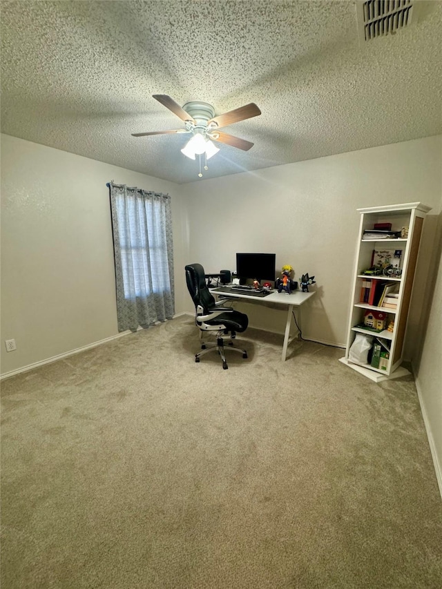 carpeted home office with ceiling fan and a textured ceiling