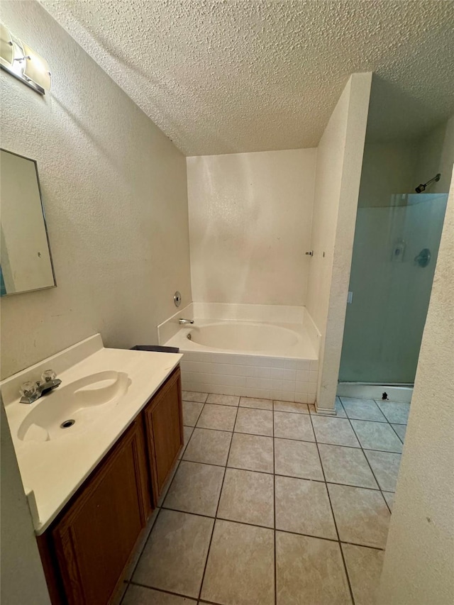 bathroom with tile patterned flooring, shower with separate bathtub, vanity, and a textured ceiling