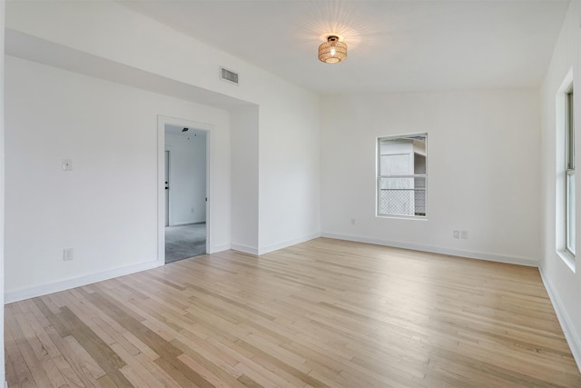 empty room with light hardwood / wood-style flooring and vaulted ceiling