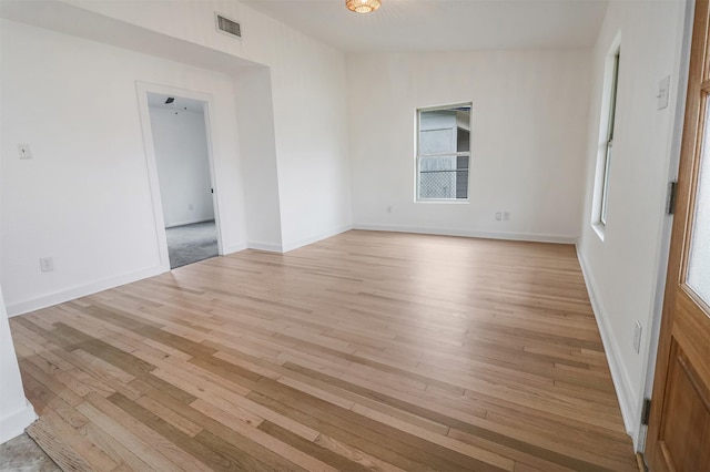 spare room with lofted ceiling and light wood-type flooring