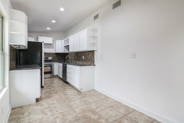 kitchen with stainless steel appliances, white cabinetry, sink, and decorative backsplash