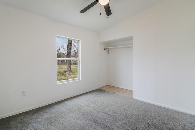 carpeted spare room featuring ceiling fan and lofted ceiling