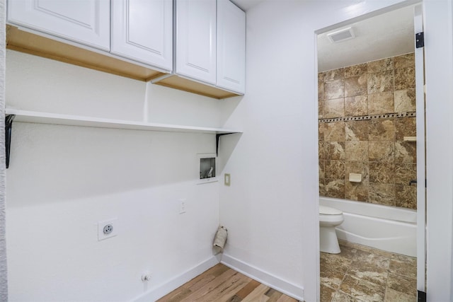 washroom with cabinets, hookup for an electric dryer, and hookup for a washing machine