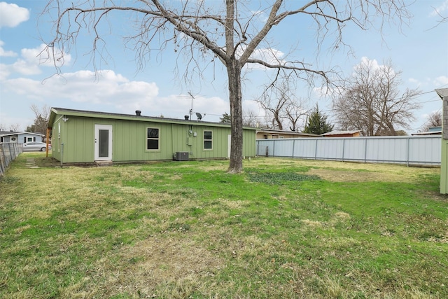 back of property featuring cooling unit and a lawn