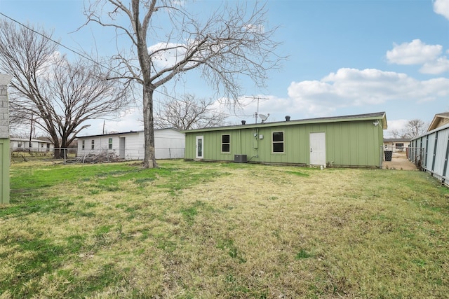 rear view of house featuring cooling unit and a yard