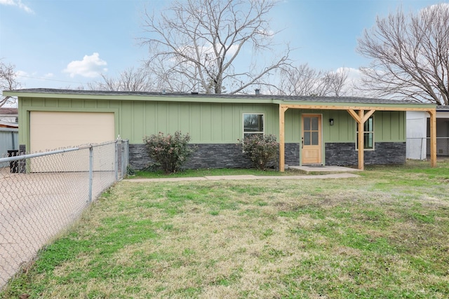 rear view of property featuring a garage and a yard