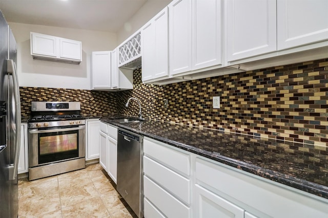 kitchen with sink, white cabinets, backsplash, dark stone counters, and stainless steel appliances