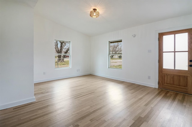 interior space with lofted ceiling, a wealth of natural light, and light hardwood / wood-style floors