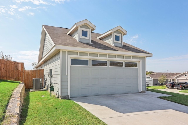 exterior space featuring a garage, a yard, and central AC