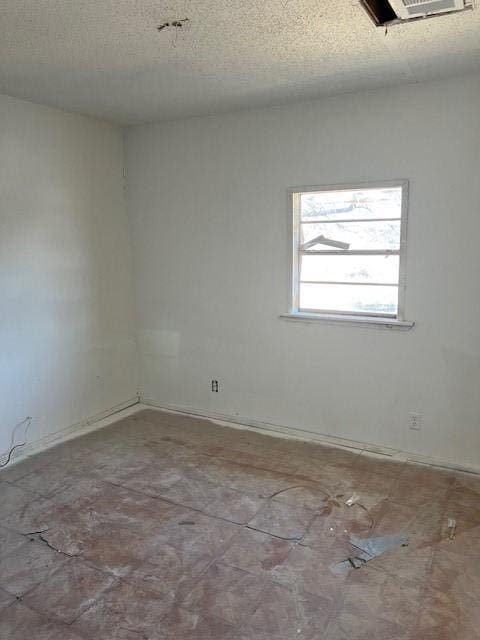 unfurnished room featuring a textured ceiling