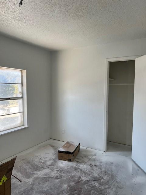 unfurnished bedroom with a textured ceiling and a closet