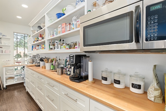 interior space featuring recessed lighting, stainless steel microwave, and dark wood-style flooring