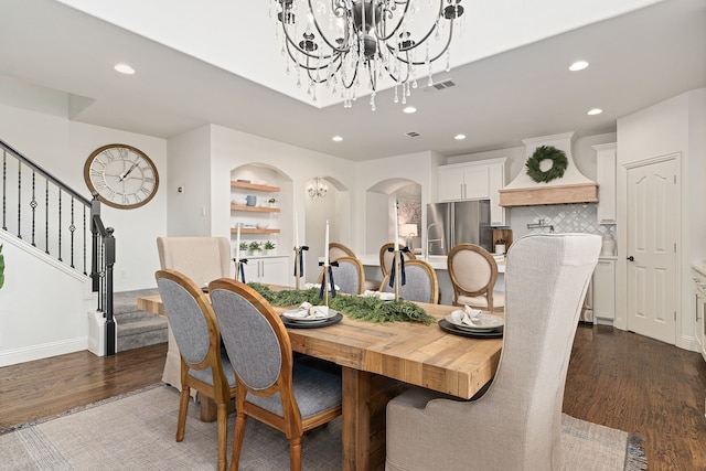 dining area featuring visible vents, dark wood finished floors, an inviting chandelier, recessed lighting, and stairs