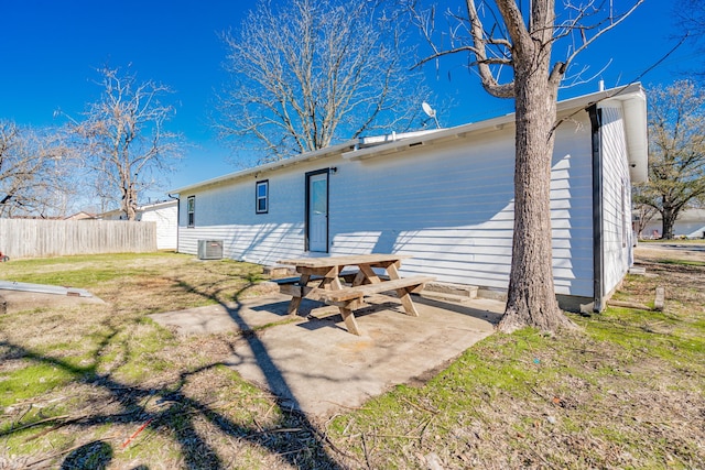 rear view of property featuring cooling unit, a patio area, and a lawn