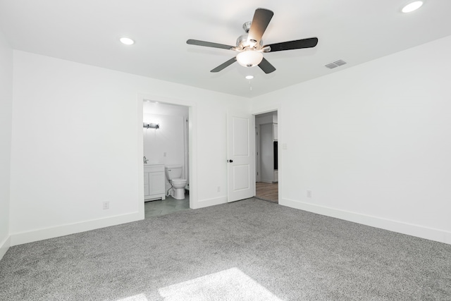 unfurnished bedroom featuring ceiling fan, carpet floors, and ensuite bath