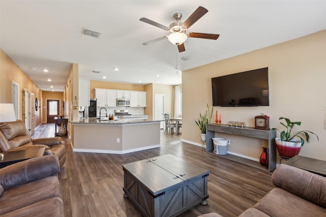 living room featuring plenty of natural light, dark hardwood / wood-style floors, and ceiling fan