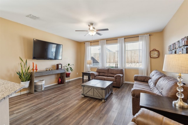 living room with dark hardwood / wood-style flooring and ceiling fan