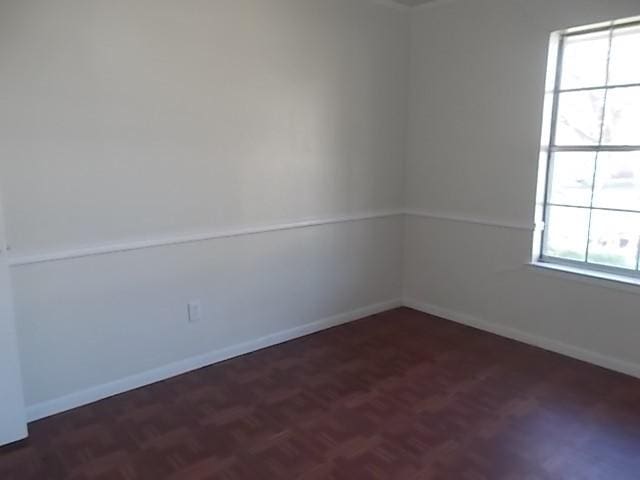 empty room featuring dark parquet flooring