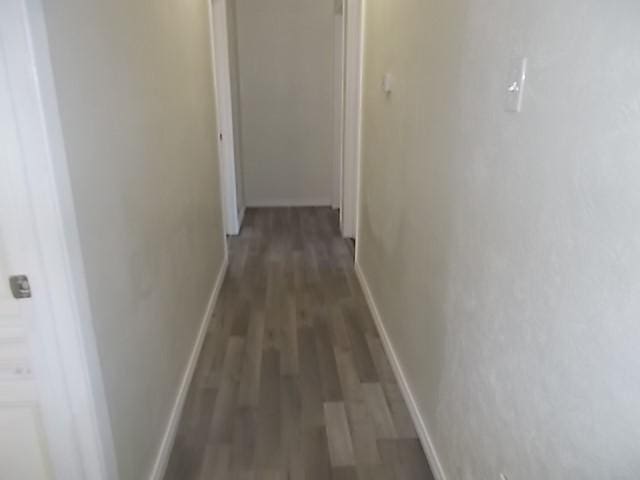 corridor with dark hardwood / wood-style flooring