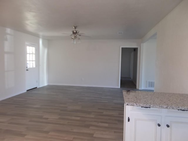 interior space with dark wood-type flooring and ceiling fan