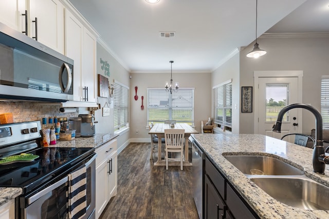 kitchen featuring appliances with stainless steel finishes, sink, pendant lighting, and white cabinets