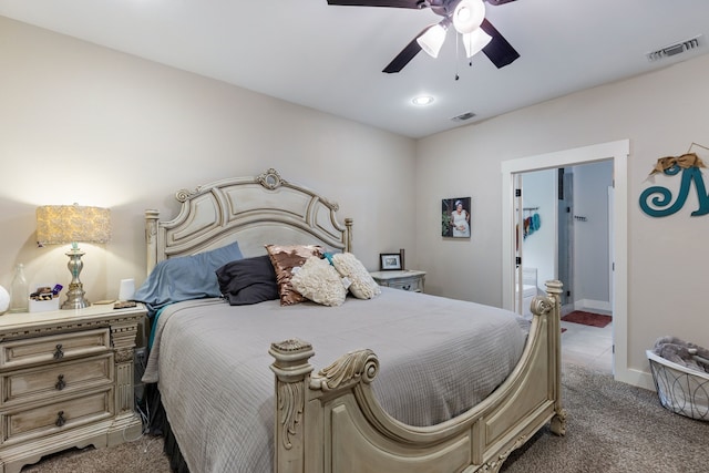 bedroom with dark colored carpet, ensuite bathroom, and ceiling fan