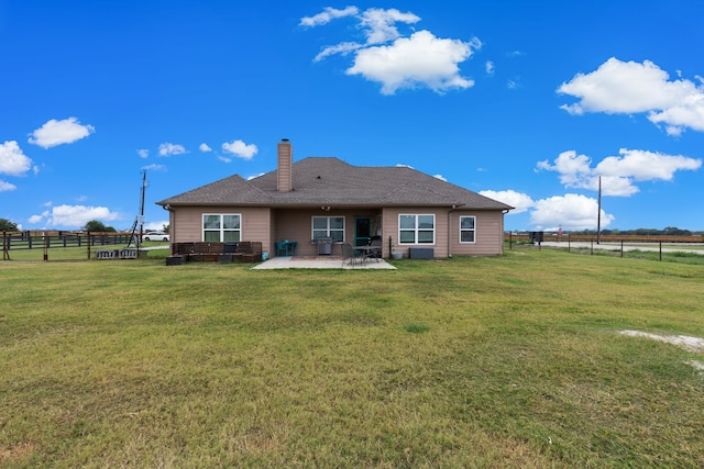 back of house featuring a rural view, a yard, and a patio area