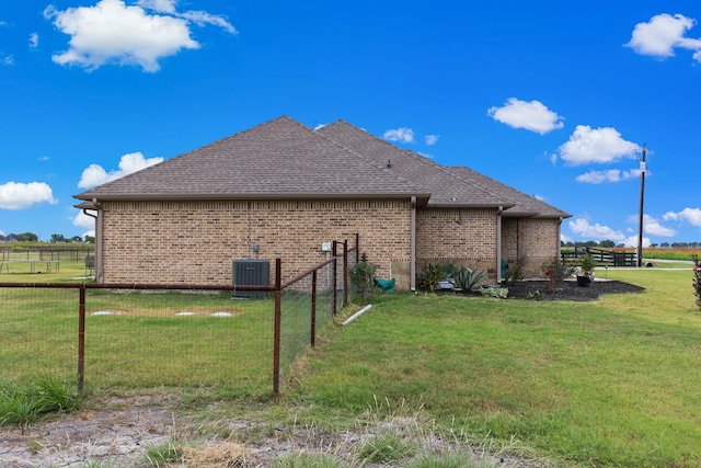 view of side of property featuring central AC and a lawn