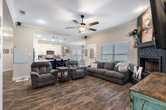 living room featuring ornamental molding, dark hardwood / wood-style floors, ceiling fan, and a fireplace