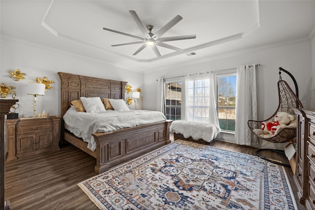 bedroom with dark wood-type flooring, ceiling fan, and a raised ceiling