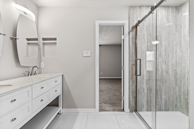 bathroom featuring double vanity, a shower stall, baseboards, and a sink