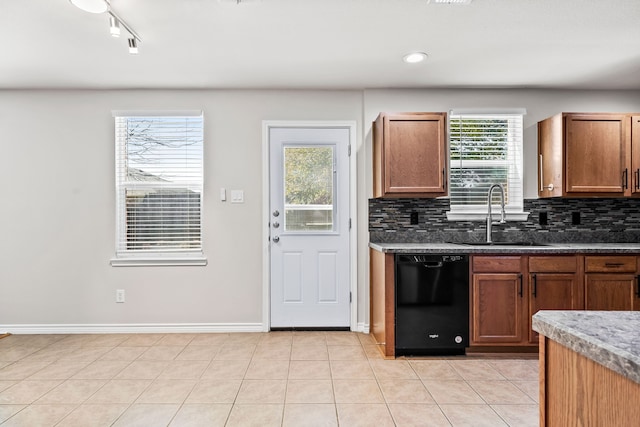 kitchen featuring tasteful backsplash, dishwasher, a sink, and light tile patterned floors