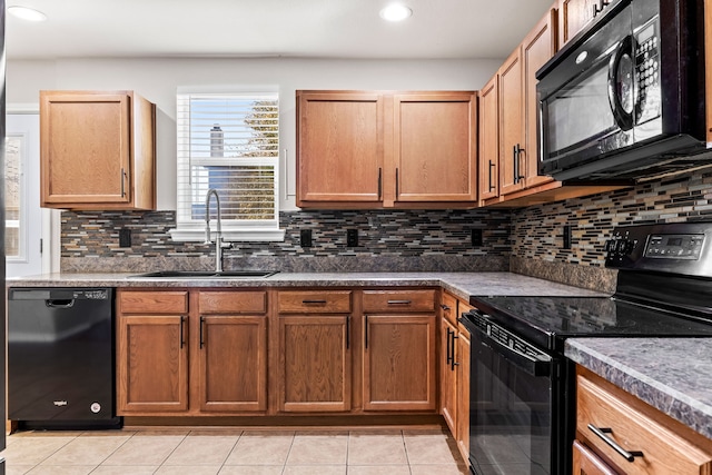 kitchen with tasteful backsplash, light tile patterned flooring, black appliances, a sink, and recessed lighting