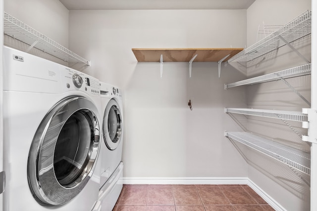 laundry room featuring laundry area, washer and clothes dryer, tile patterned flooring, and baseboards